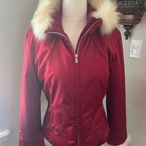 Red ski jacket with fox fur cuffs and collar.